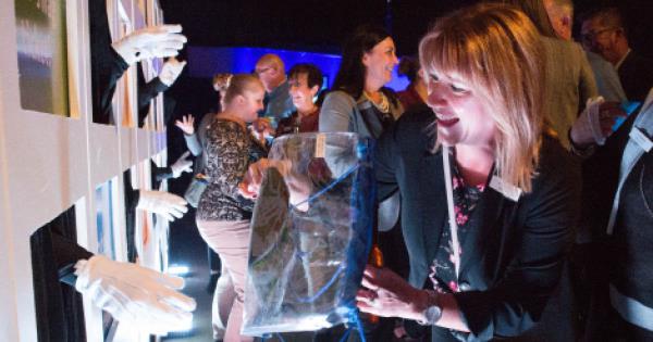 person interacting with a hand wall at an employee event